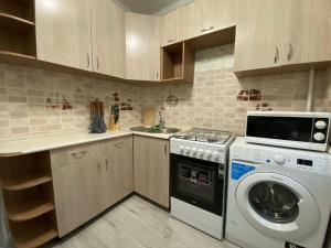a kitchen with a washing machine and a sink at Квартира на Тулебаева in Almaty