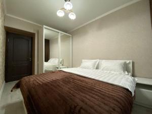 a bedroom with a large bed and a mirror at Квартира на Тулебаева in Almaty