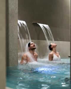 duas pessoas na água com uma cascata em Executive Spa Hotel em Fiorano Modenese