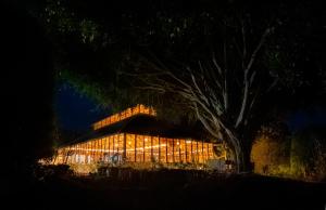 a brightly lit building with a rainbow in the background at Southern Panorama Campnoel Munnar in Vattavada