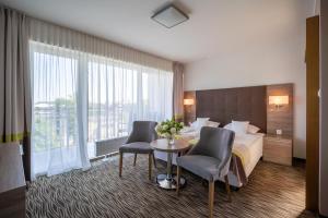 a hotel room with a bed and a table and chairs at Perła Bałtyku in Świnoujście