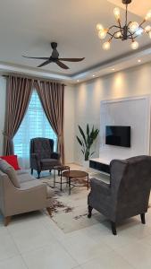 a living room with furniture and a ceiling fan at Green Homestay Tangga Batu in Tangga Batu