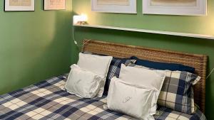 ein Bett mit drei Kissen und einer grünen Wand in der Unterkunft La Maison de Fuecopared in Florenz