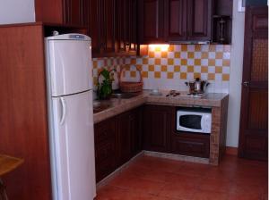 a kitchen with a white refrigerator and a microwave at The Album Loft in Patong Beach