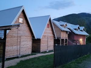 a row of wooden homes with metal roofs at kamp Bungalovi sase apartman in Višegrad