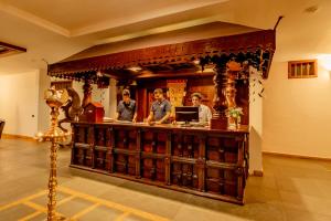 un gruppo di uomini in piedi al bancone di un bar di Southern Panorama Indriya Resorts & Spa a Munnar Altre 167 foto