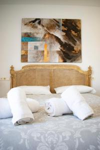 Una cama con toallas y una pintura. en Penthouse Tarifa with Sea Views, en Tarifa