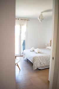 a white bedroom with a bed and a window at Penthouse Tarifa with Sea Views in Tarifa