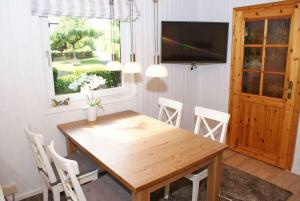 a dining room with a wooden table and chairs at Blockhaus mit W LAN sehr strandnah in Damp
