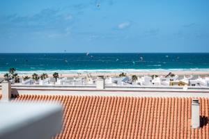 a view of a beach with white chairs and the ocean at Penthouse Tarifa with Sea Views in Tarifa