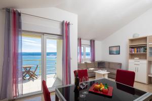 sala de estar con mesa y sillas rojas en Seaview Apartment Marita en Lokva Rogoznica