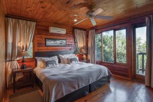 a bedroom with a bed and a ceiling fan at Kariega Game Reserve Main Lodge in Kenton on Sea