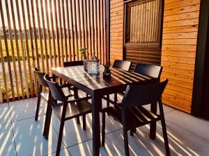 einen Holztisch und Stühle auf einer Terrasse in der Unterkunft BIG BERRY Kolpa - MerryBerry mobile house in Metlika