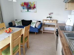 a living room with a table and a blue couch at Ferienwohnung Zammernig in Ferndorf