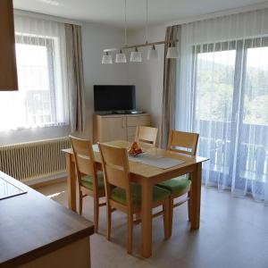 a dining room with a table and chairs and a television at Ferienwohnung Zammernig in Ferndorf