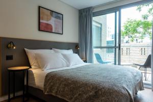 a bedroom with a bed and a large window at Urbanic Hotel in Jerusalem