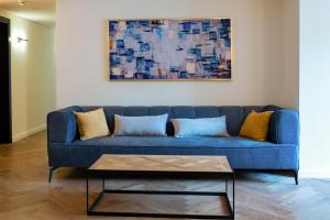 a blue couch in a living room with a painting at Urbanic Hotel in Jerusalem