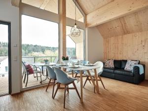 a dining room with a table and chairs and a couch at Ferienhäuser Fischer Wagenhausen in Bad Saulgau