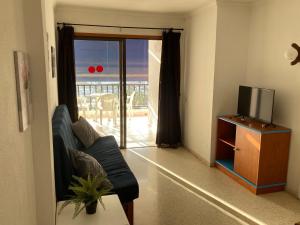sala de estar con sofá y TV en Spacious flat with ocean view, en Puerto Rico de Gran Canaria