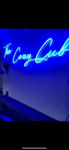 a blue neon sign that says the cozy lane at The Cozy Cub in Romsey