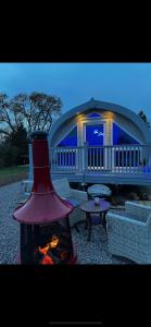 a fireplace in front of a large house with a table at The Cozy Cub in Romsey +16 photos