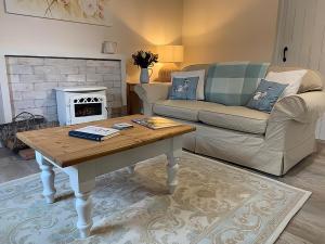 a living room with a coffee table and a couch at Hawthorn Cottage at Waingrove Farm in Fulstow