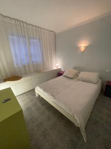 ein Schlafzimmer mit einem weißen Bett und einem Fenster in der Unterkunft DOMUS in Canet-en-Roussillon