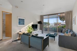 a living room with two couches and a tv at APARTMENT 4A - By the Beach in Paraparaumu Beach