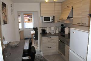 eine Küche mit Holzschränken und einem weißen Kühlschrank in der Unterkunft Haus Karin Ferienwohnung 3 in Büsum