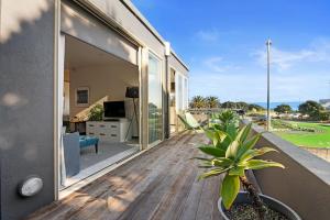 a balcony with a view of the ocean from a house at APARTMENT 4A - By the Beach in Paraparaumu Beach