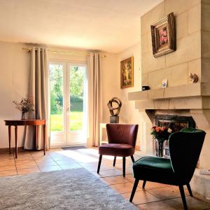sala de estar con chimenea y silla en Chambre d'hôtes, en La Membrolle-sur-Choisille