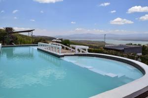 a swimming pool with a view of the water at Lemon Valley Farm in Elmenteita