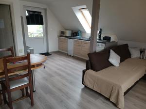 a living room with a couch and a table at Au fil du Bonheur studio climatisé in Surbourg