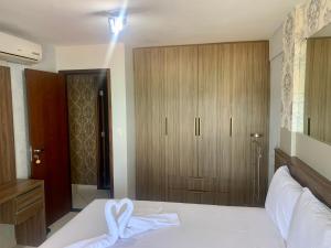 1 dormitorio con 1 cama blanca y armario de madera en Terrazzo Ponta Negra 2 Quartos Vista Mar, en Natal