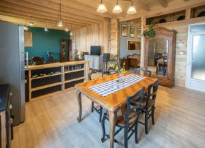 cocina y comedor con mesa de madera y sillas en Appartement de charme dans une maison isolée, en Présilly
