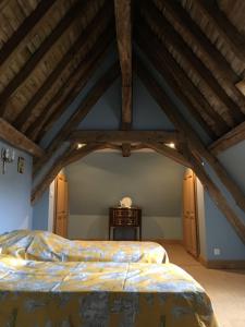 a bedroom with a large bed and wooden ceilings at Le Petit Dauphin in Couleuvre
