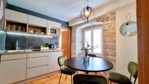 - une cuisine avec une table et des chaises dans la chambre dans l'établissement Etal Luxury Apartment, à Dubrovnik