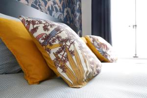 a group of pillows sitting on top of a bed at Domaine Saint-Hilaire in Meung-sur-Loire