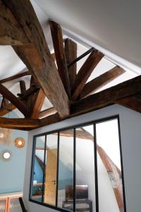 a ceiling with wooden beams and a window at Domaine Saint-Hilaire in Meung-sur-Loire