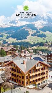 a view of a building with a mountain in the background at Apart Hotel Adelboden am Dorfplatz in Adelboden