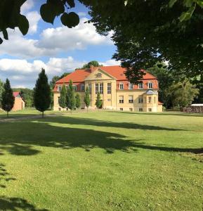 a large yellow house with a large grass field at Schloss Grabow, Resting Place & a Luxury Piano Collection Resort, Prignitz Brandenburg in Grabow