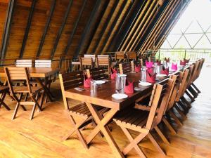 a long table with pink napkins on top of it at Lolu Village Resort in Anuradhapura