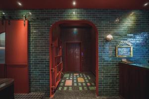 a hallway with a red door in a brick wall at Getcha Hostel in Taichung