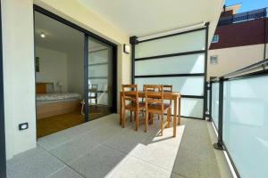 a dining room with a table and chairs and a bedroom at Apparté - Appartement proche Genève et Palexpo in Ferney-Voltaire