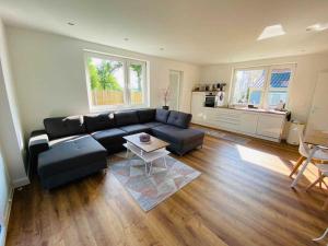 a living room with a black couch and a table at Ferienhäuschen Seenrunde 