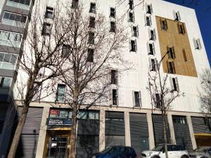 un edificio alto con coches estacionados frente a él en Résidence Néméa Student Arena, en Toulouse