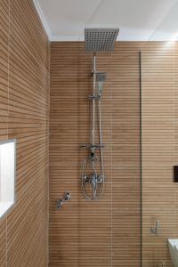 y baño con ducha y pared de madera. en Veria Panorama Luxury Suite With Garden., en Veria