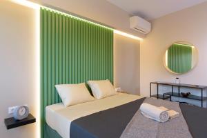 a bedroom with a bed with a green wall at Indigo Luxury apartment in Agios Nikolaos +26 photos