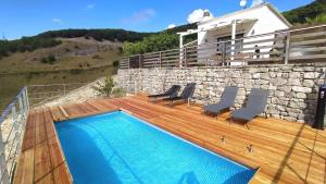 una piscina su una terrazza con sedie e un edificio di Villetta Bonifato ad Alcamo