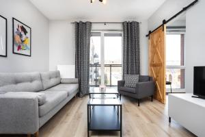 ein Wohnzimmer mit einem Sofa und einem Tisch in der Unterkunft City of the Kings-Alice Apartment in Krakau